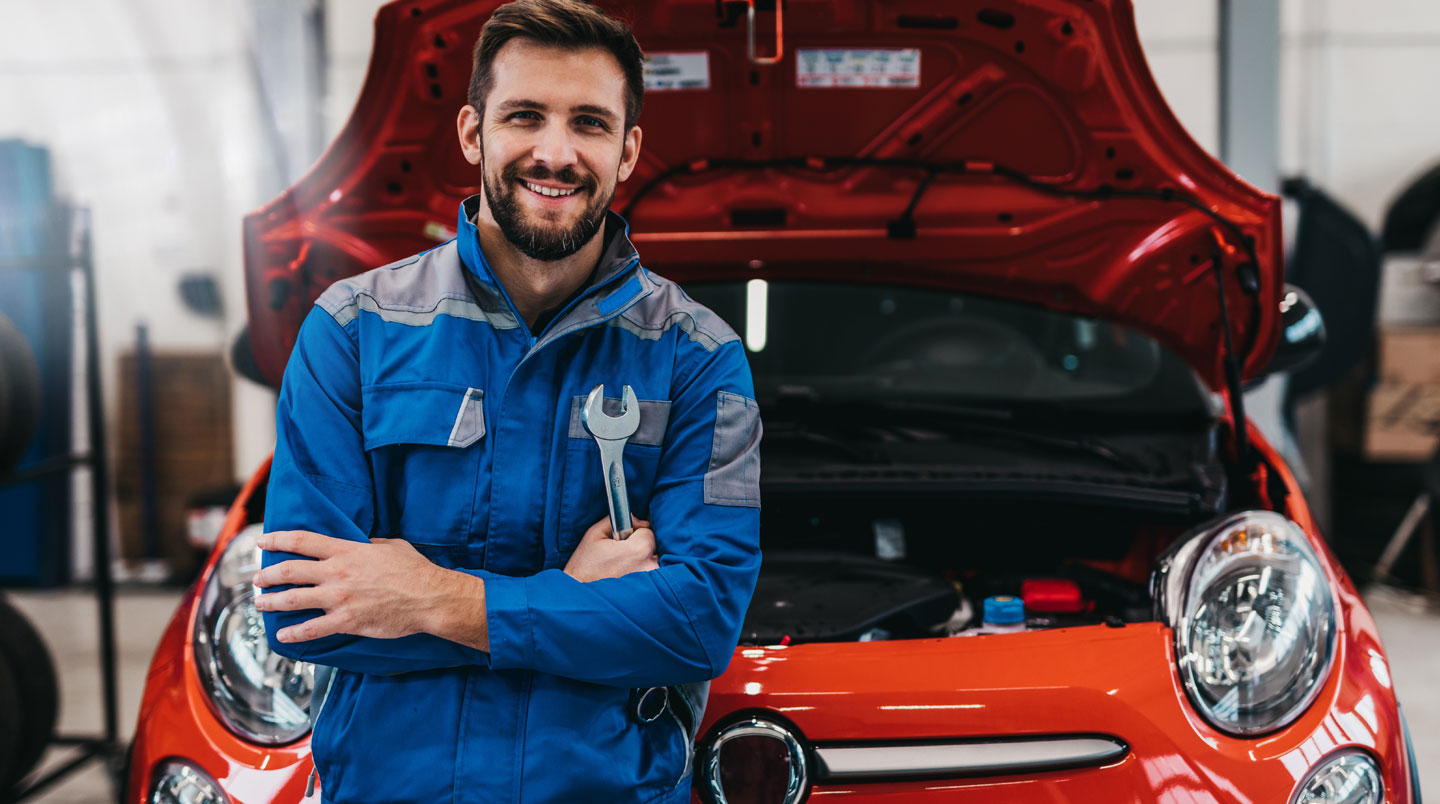 Mécanicien en bleu de travail inspectant le moteur d